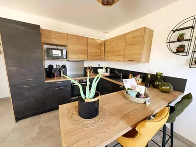 Cuisine ou kitchenette dans l'établissement Les Rochers - Raffinement boisé & Plage à 5 min en voiture - Sérénité