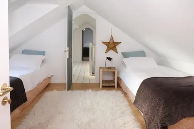 Un ou plusieurs lits dans un hébergement de l'établissement La Maison des Rues Pavées avec jardin by La Boîte En Plus