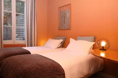 Un ou plusieurs lits dans un hébergement de l'établissement La Maison des Rues Pavées avec jardin by La Boîte En Plus