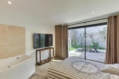 Un ou plusieurs lits dans un hébergement de l'établissement Bel appartement rdc détente Balnéo & Ciné & Terrasse proche Centre Gare Amiens