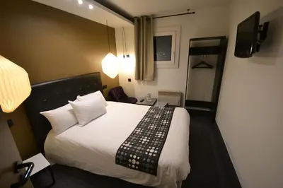 Un ou plusieurs lits dans un hébergement de l'établissement Brit Hotel Baillet-en-France
