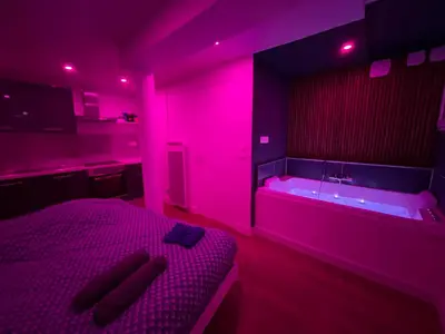 Un ou plusieurs lits dans un hébergement de l'établissement Nuit magique jacuzzi, terrasse & lit motorisé - 008