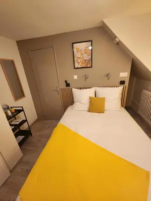 Un ou plusieurs lits dans un hébergement de l'établissement chambre jaune