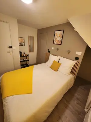 Un ou plusieurs lits dans un hébergement de l'établissement chambre jaune