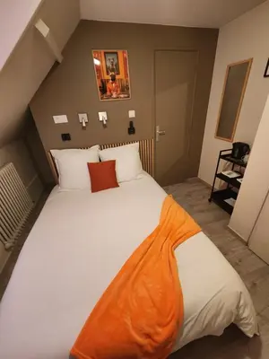 Un ou plusieurs lits dans un hébergement de l'établissement chambre orange