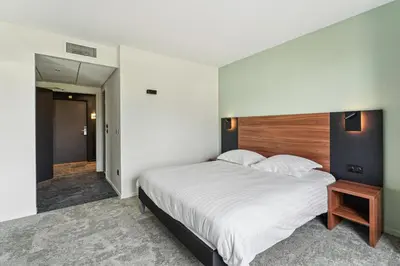 Un ou plusieurs lits dans un hébergement de l'établissement Hôtel Akena Pierrelaye