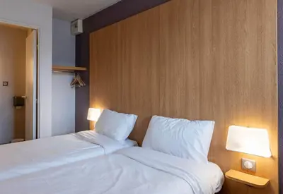 Un ou plusieurs lits dans un hébergement de l'établissement B&B HOTEL Amiens Longueau