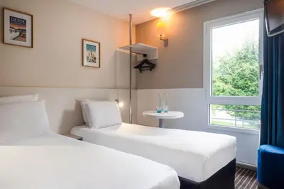 Un ou plusieurs lits dans un hébergement de l'établissement Hôtel Kyriad Dieppe