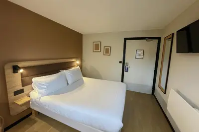 Un ou plusieurs lits dans un hébergement de l'établissement Brit Hotel Confort Rouen Centre