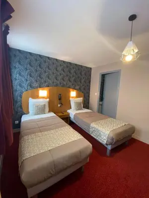 Un ou plusieurs lits dans un hébergement de l'établissement Logis - Hôtel et Restaurant Le Sofhotel