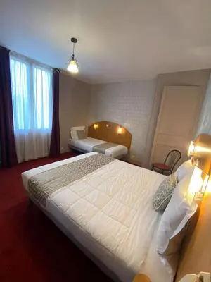 Un ou plusieurs lits dans un hébergement de l'établissement Logis - Hôtel et Restaurant Le Sofhotel