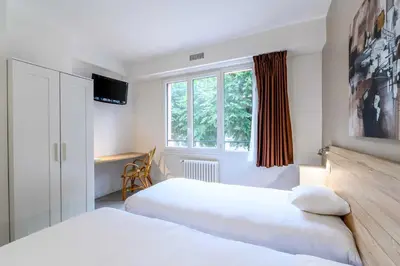 Un ou plusieurs lits dans un hébergement de l'établissement Hôtel Rouen Alba