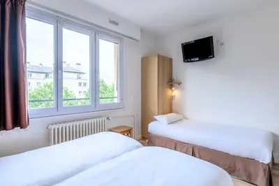 Un ou plusieurs lits dans un hébergement de l'établissement Hôtel Rouen Alba
