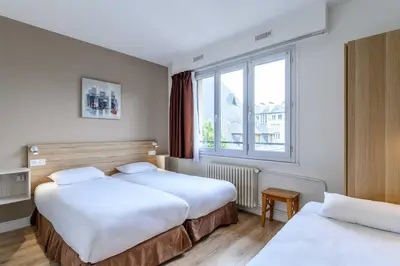 Un ou plusieurs lits dans un hébergement de l'établissement Hôtel Rouen Alba