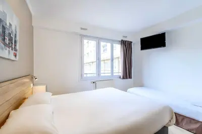Un ou plusieurs lits dans un hébergement de l'établissement Hôtel Rouen Alba