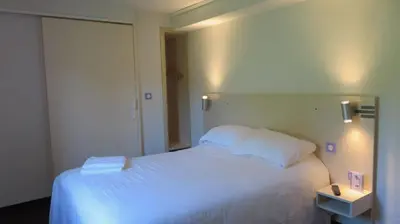 Un ou plusieurs lits dans un hébergement de l'établissement Brit Hotel Rouen Sud Val De Reuil