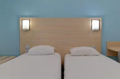 Un ou plusieurs lits dans un hébergement de l'établissement Hotel Restaurant Les Jardins D'Epône