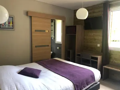 Un ou plusieurs lits dans un hébergement de l'établissement Logis Hotel Le Val Sarah