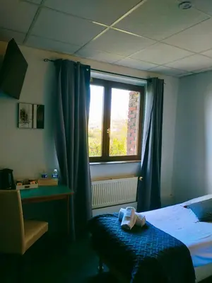Un ou plusieurs lits dans un hébergement de l'établissement Hôtel Restaurant l’Éolienne