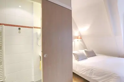 Un ou plusieurs lits dans un hébergement de l'établissement Hôtel Cardinal