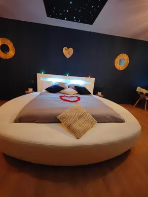 Un ou plusieurs lits dans un hébergement de l'établissement Gite Romantique avec Espace Balnéo et Ciel Etoilé 